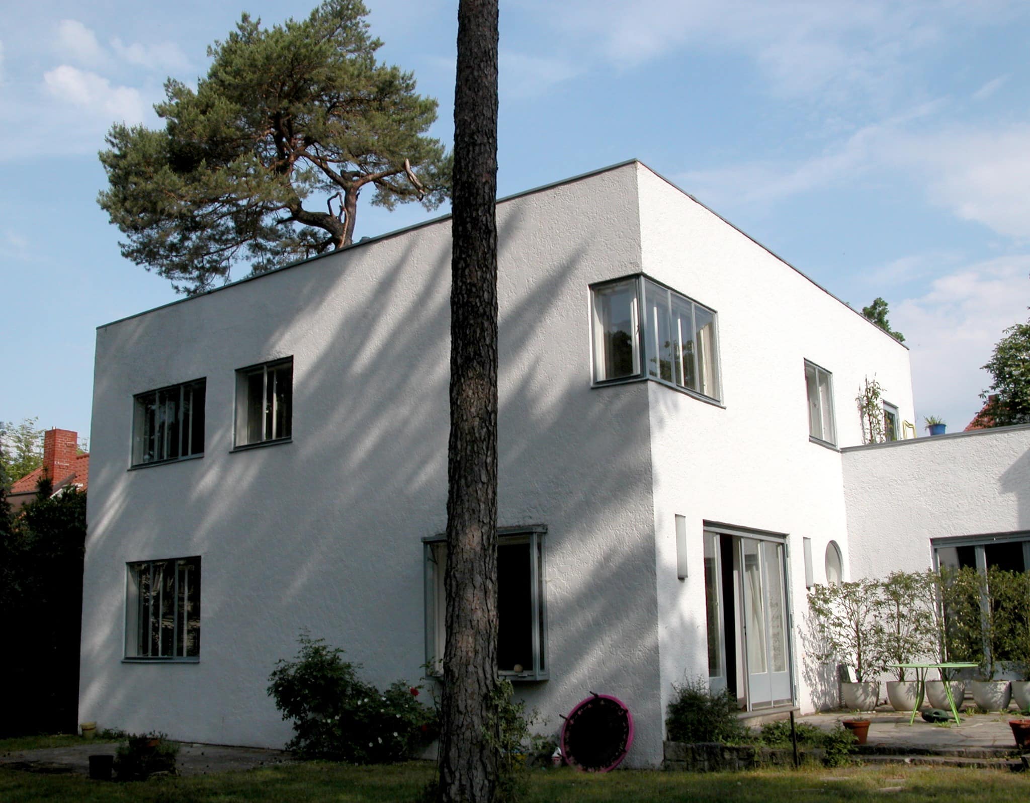 Gartenseite des Haus Lewin mit weißer kubischer Fassade und altem Baumbestand