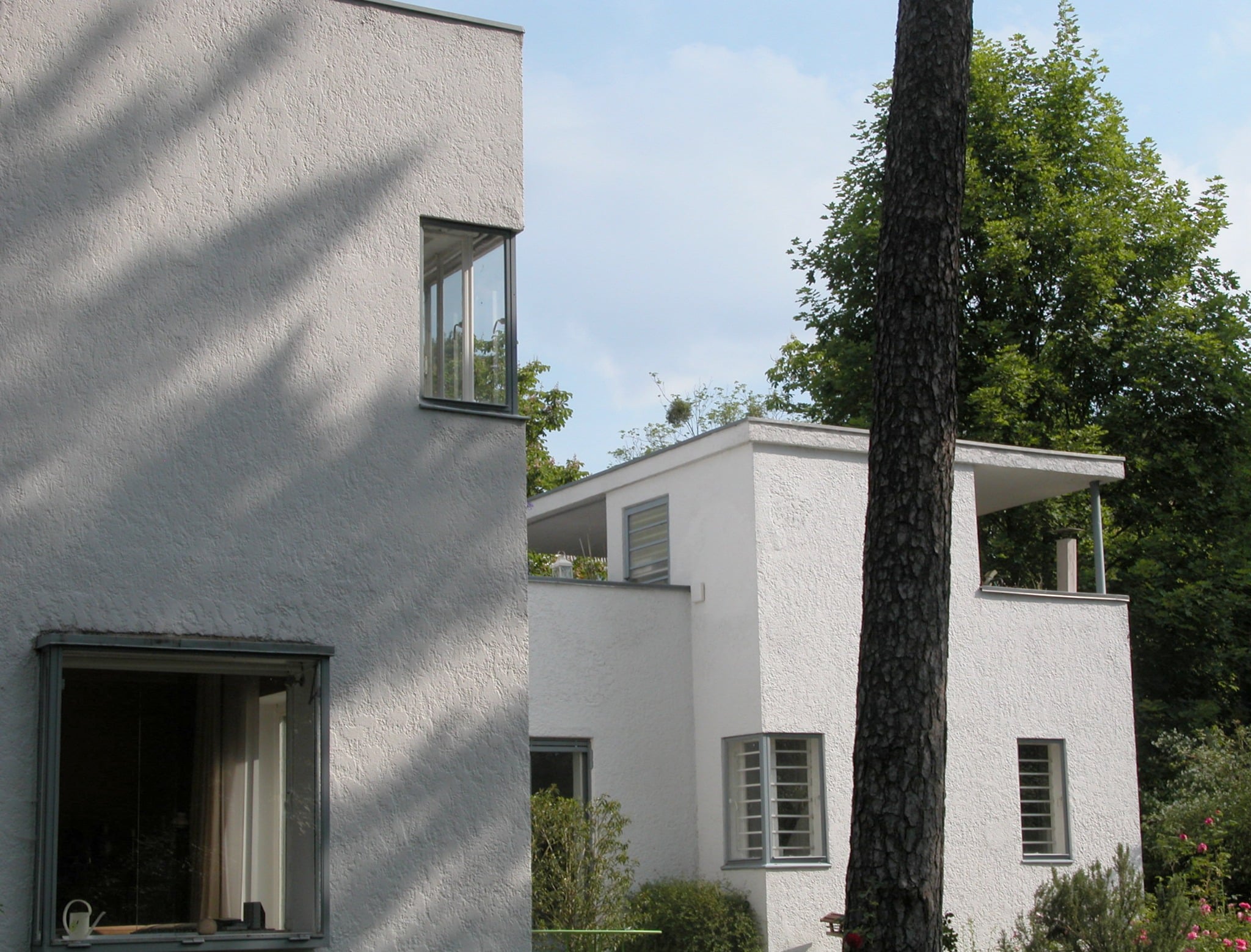 Haupthaus und kleinerer Kubus des Haus Lewin mit Dachterrasse und Stahlfenstern